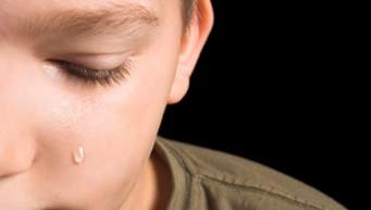 Half boy's face with single tear